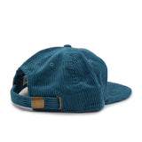 Blue corduroy cap with a brown patch on a white background