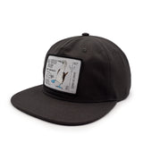 side view of a black cap with a blue footed booby patch on a white background