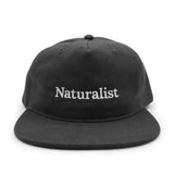 Black cap with 'Naturalist' text on a white background