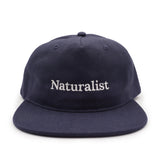 Navy blue cap with 'Naturalist' text on a white background
