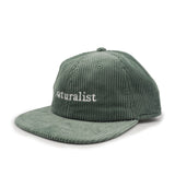Green corduroy cap with 'naturalist' embroidery on a white background