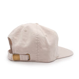 Beige cap with a brown leather strap on a white background