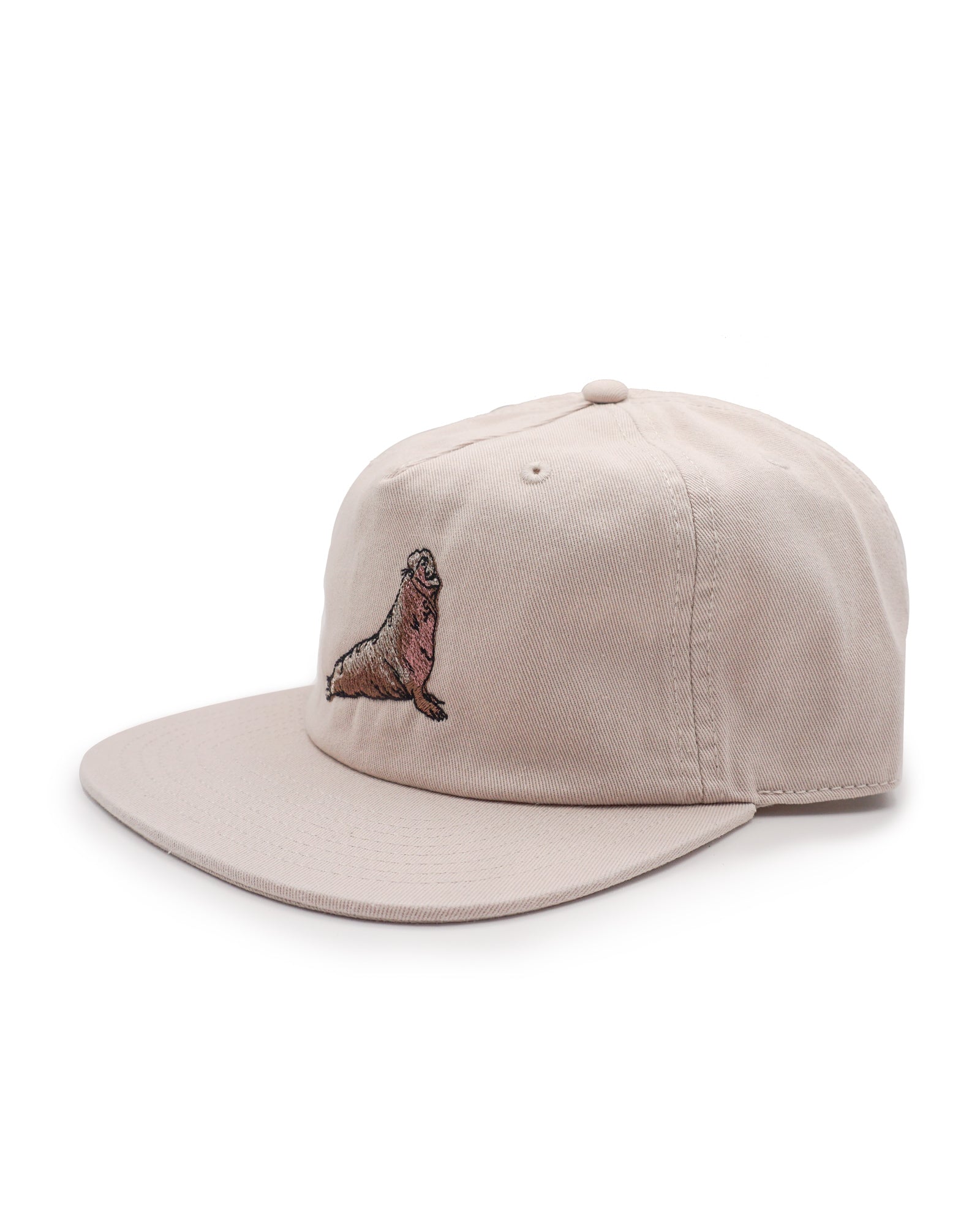 Side view of a beige cap with an elephant seal on a white background