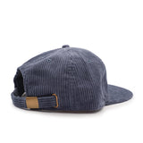Blue corduroy cap with a brown patch on a white background