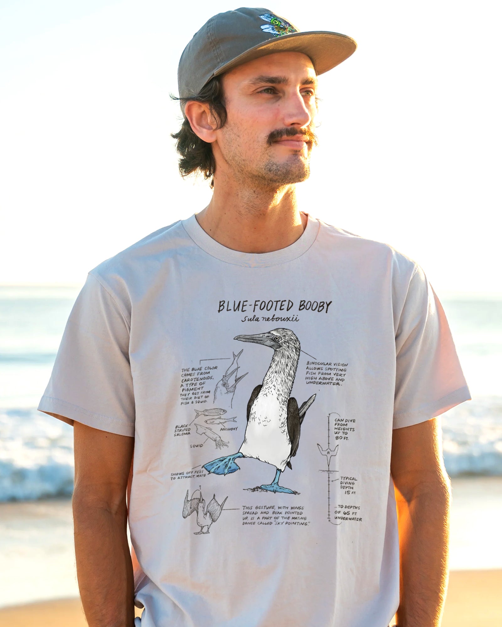 man wearing a t-shirt with an illustration of a lue-footed booby