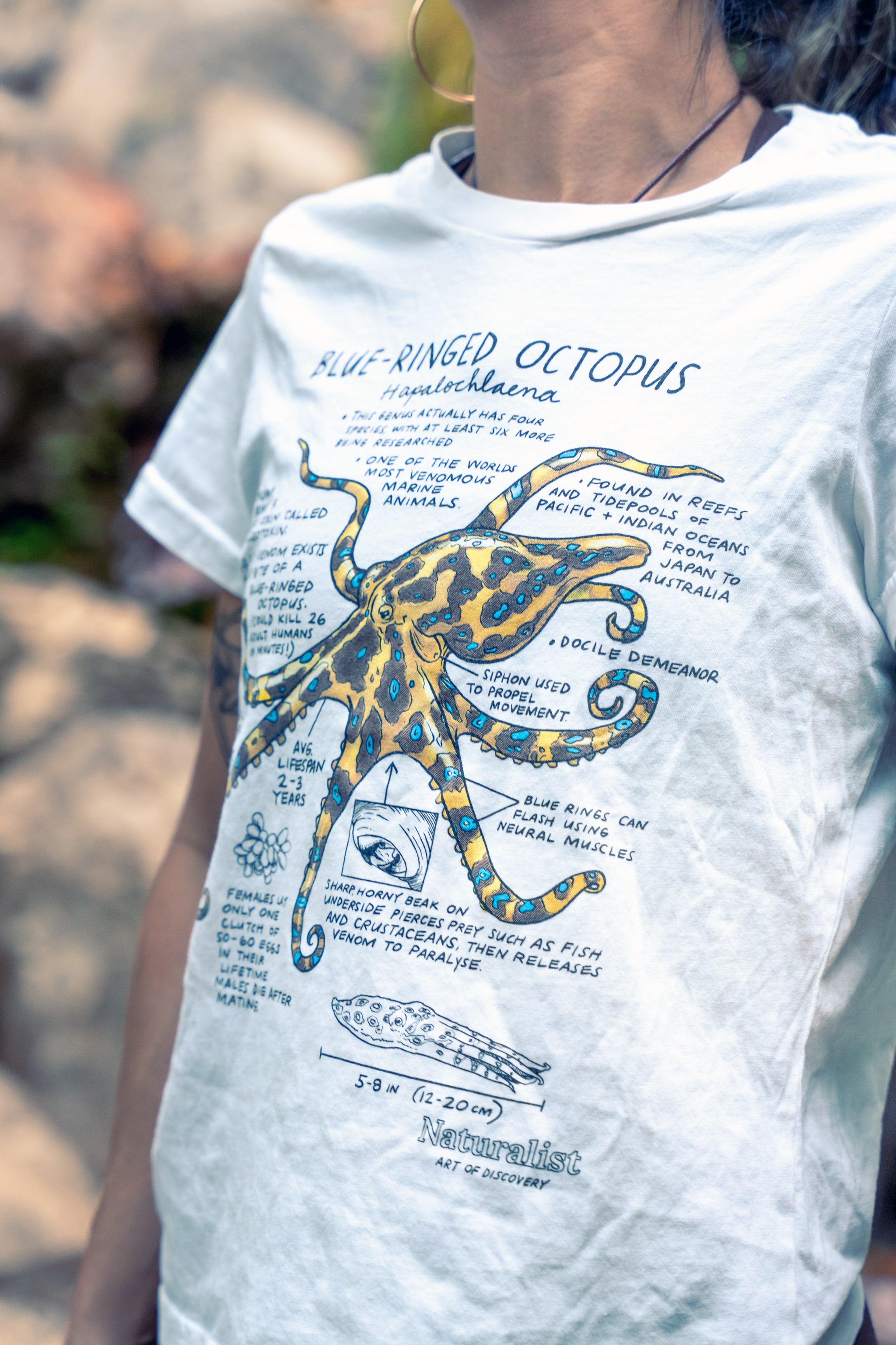 Person wearing a t-shirt with a blue-ringed octopus graphic and text.