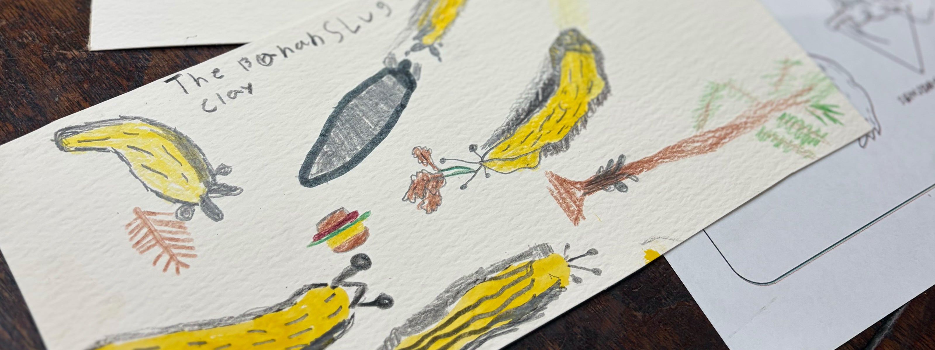 Children's drawing of bananas and a spoon on a piece of paper.