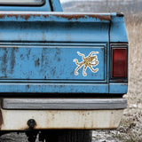Rustic blue truck with a white and yellow blue ringed octopus decal on the back