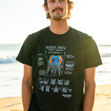 Man wearing a black t-shirt with peacock spider illustration n on a beach